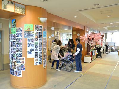 柱に貼ってある写真は、華道・園芸・カラオケ・お出かけなどのイベント時の写真。利用者様の明るい笑顔がいっぱいです。