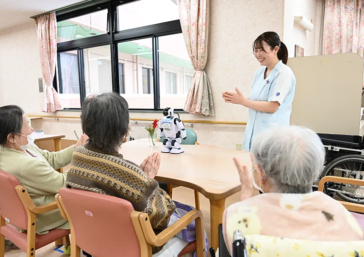 介護スタッフの仕事風景。レクリエーションでは、介護ロボット「パルロ」を活用して楽しんでいます。