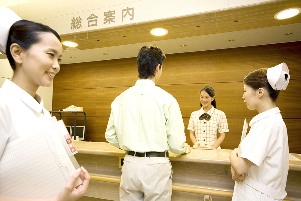 病院の受付前の看護師